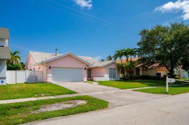 Yeşil çimen ve mavi gökyüzü olan modern bir ev.