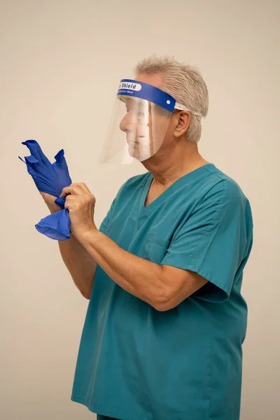 医生或护士戴上护目镜 戴上蓝色胶乳手套 — 图库照片