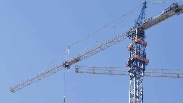 Eje de la grúa de construcción en un cielo azul — Vídeos de Stock