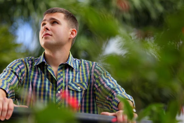 Schöner russischer Mann posiert in einem Garten — Stockfoto