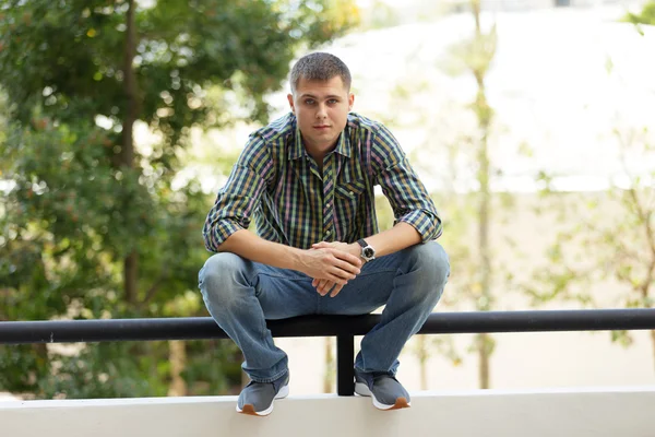 Man sitting on the ledge — Stock Photo, Image