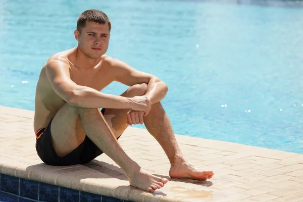 Man sunbathing by the pool — Stock Photo, Image