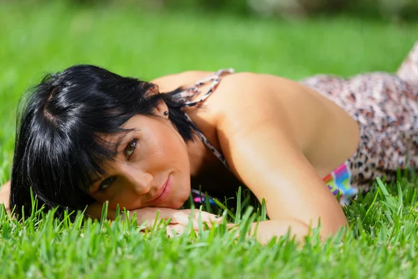 Yeşil çimenlerin üzerinde döşeme kadın — Stok fotoğraf
