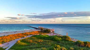 Günbatımında Miami Beach South Pointe Parkı 'nı ziyaret et. Atlantik Okyanusu 2025 'e giriş ve iskeleyi gösteren havadan yükselen bir video.
