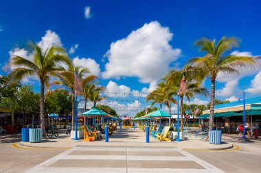 Lauderdale By The Sea, FL, ABD - 8 Kasım 2025: Melvin L Anglin Meydanı. Lauderdale Deniz Ticari Sahili. Avuç içleri olan renkli sandalyeler