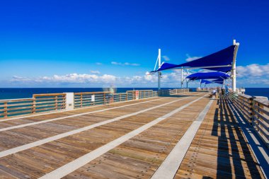 Pompano Sahili Balıkçılık İskelesi Atlantik Okyanusu üzerinde. Bulutlara ve insanlara uzun süre maruz kalmak