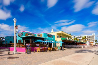 Hollywood, FL, ABD - 4 Aralık 2025 Hollywood Beach Florida 'daki barlar ve restoranlar. Bulanık insanlara ve gökyüzüne uzun süre maruz kalmak