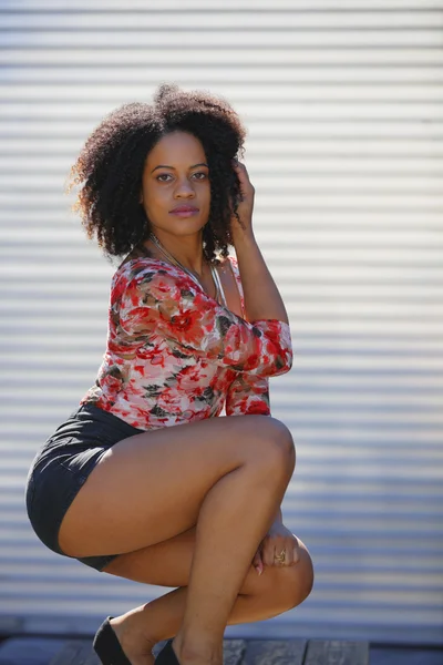 Mujer posando sobre una mesa con las piernas dobladas — Foto de Stock