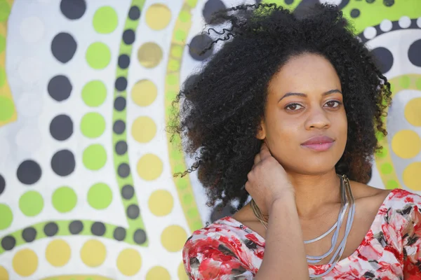 Mujer sonriendo con un fondo de arte colorido — Foto de Stock