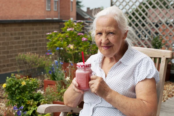 Elderly woman with smoothie — Stock Photo, Image