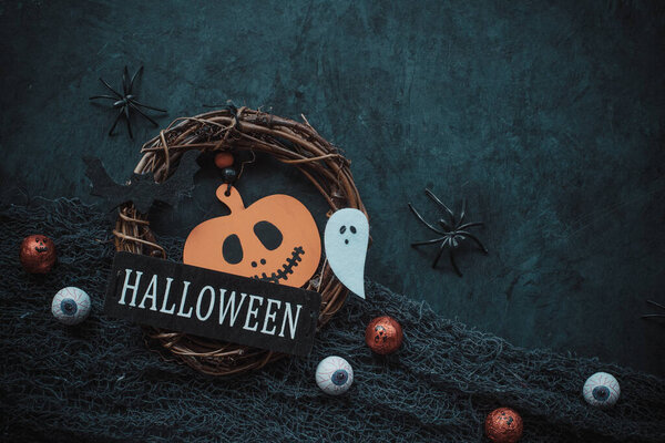 Halloween card with pumpkin decor, candy and spiders on dark grunge background. Place for text