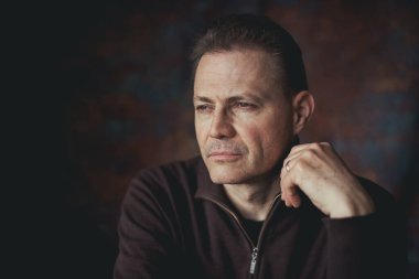 Kendine güvenen ciddi bir adamın portresi. Günlük kıyafetler giymiş, düşünceli bir görünüm. Metin için yer