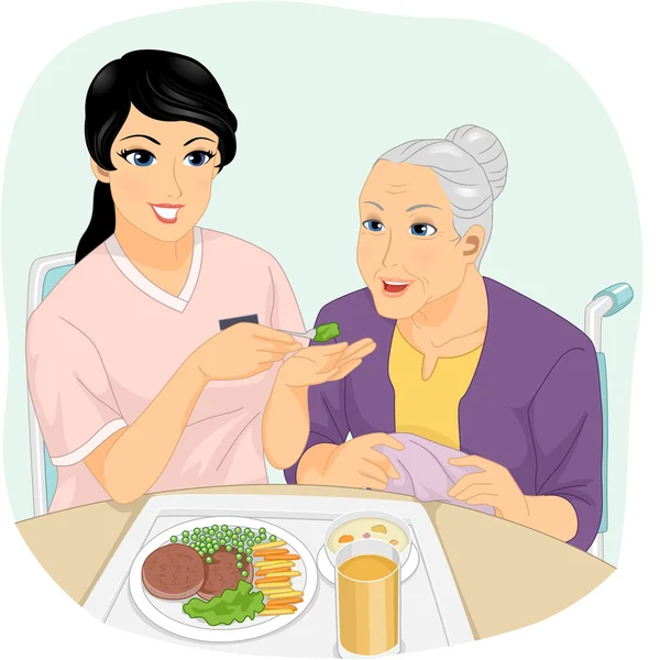 Zdravotní sestra pomáhá důchodce jíst — Stock fotografie