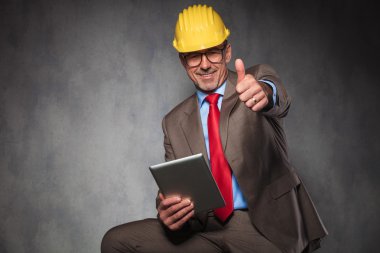 engineer showing thumbs up while holding his tablet