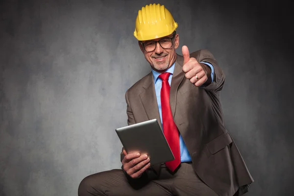 Engineer showing thumbs up while holding his tablet — Stock Photo, Image