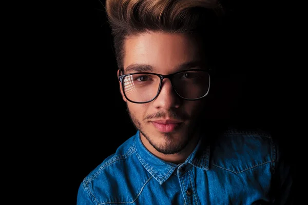 Улыбающийся красивый мужчина в джинсовых очках в студии — стоковое фото