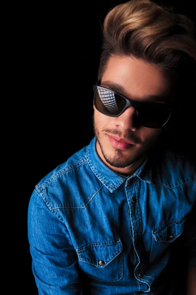 Jovem sorridente de camisa jeans usando óculos de sol — Fotografia de Stock