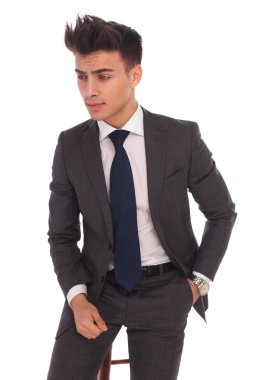 bir sandalyede oturan bir ciddi genç iş adamı yan görünüm 