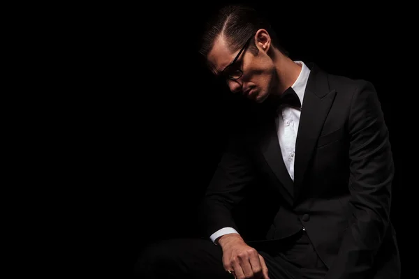 Classy man in black wearing glasses posing in dark — Stock Photo, Image