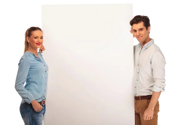 Couple posing holding a white billboard — Stok fotoğraf