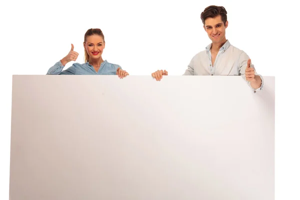 Pareja posando sosteniendo un cartel en blanco — Foto de Stock