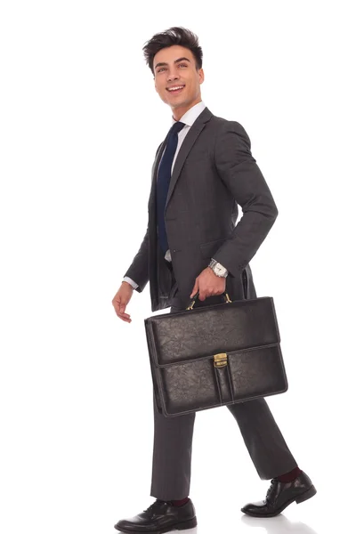 Ходьба бізнесмен з портфелем, дивлячись вгору і сміючись — стокове фото