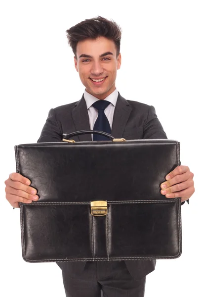 Joven hombre de negocios sonriente mostrando un maletín —  Fotos de Stock