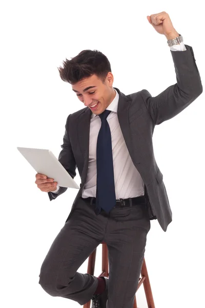 Homem de negócios comemorando boas notícias que lê neste tablet — Fotografia de Stock