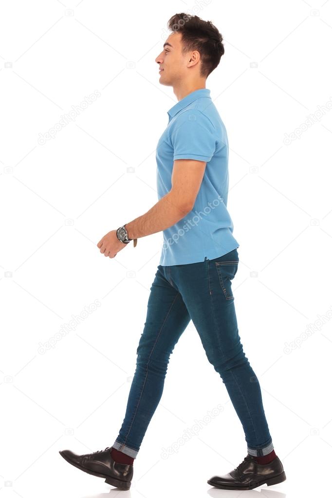 man in blue shirt walking in isolated studio background