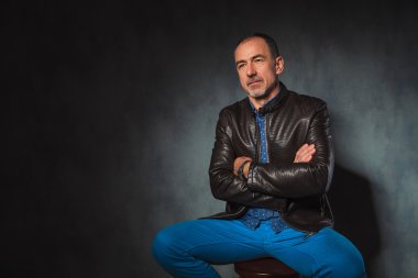 deri ceketli oturmuş olgun adam