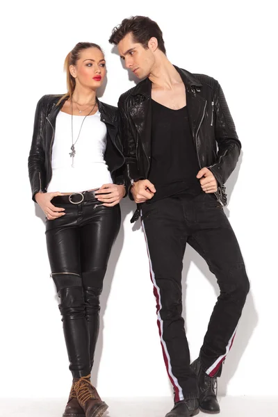 Jovem casal de moda em roupas de couro olhando um para o outro — Fotografia de Stock