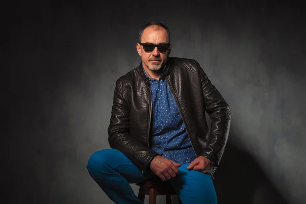 seated mature successful man in leather