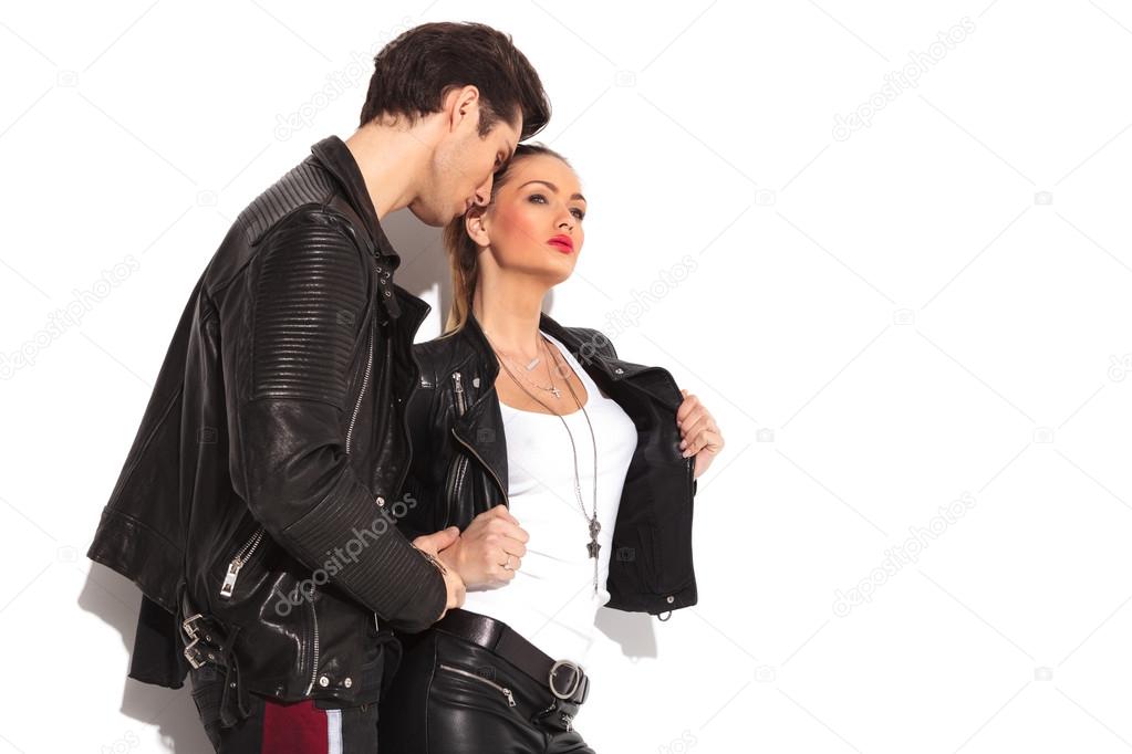 man holding his girlfriend while she opens her leather jacket
