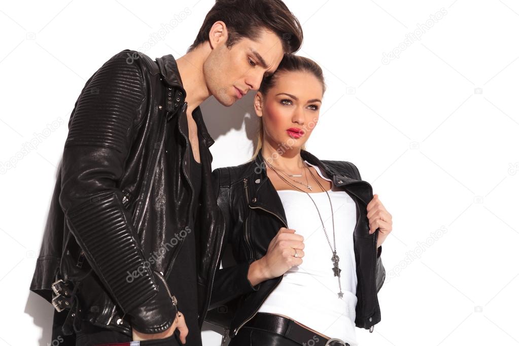man next to woman pulling her jacket's collar