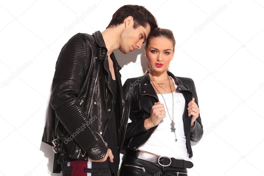 hot young couple in leather clothes standing together