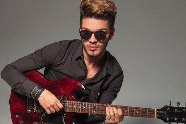 gülümseyen genç adam bir electirc gitar çalmak 