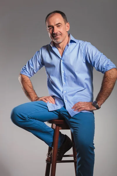 Bearded casual man in jeans posing seated — Stock Photo, Image