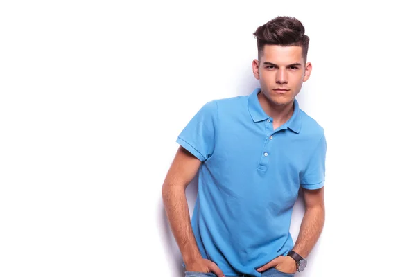 Jongen in het poloshirt poseren handen in de zakken terwijl leunend — Stockfoto