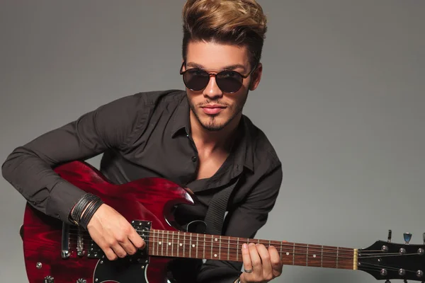 Smiling young man playing an electirc guitar — Stock Photo, Image