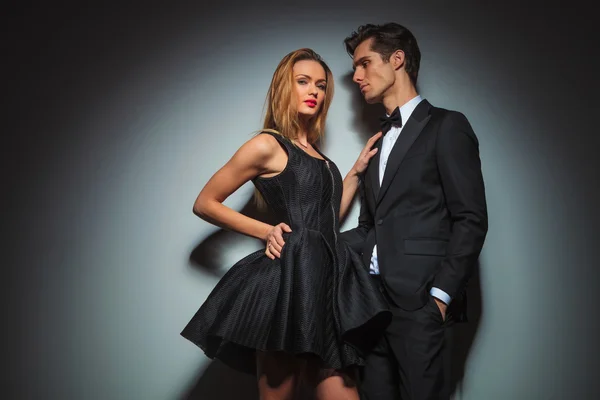 Elegante casal em preto abraçando no estúdio cinza — Fotografia de Stock