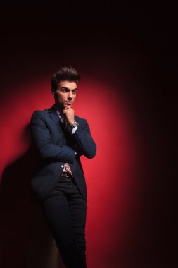kırmızı stüdyo arka planda siyah ayakta dalgın işadamı