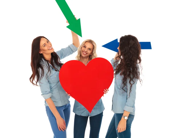 Drei lässige Frauen zeigen ihr großes Herz mit Pfeilen — Stockfoto