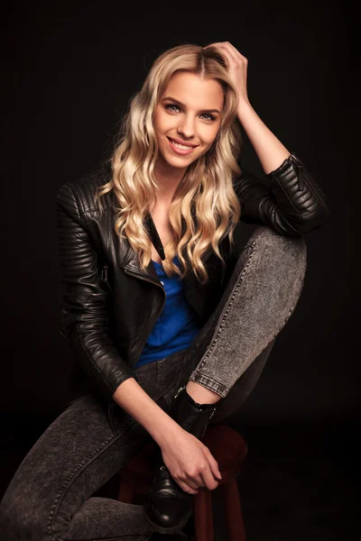 Blond woman in leather jacket resting her head on hand — Stock Photo, Image
