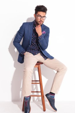 Takım elbiseli genç adam sandalyede otururken düşünüyorum