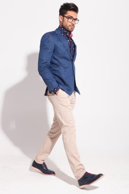 Elleri ceplerinde yürüyüş ile ciddi zarif adam 