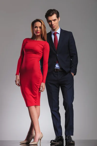 Сексуальная блондинка в красном платье стоит рядом с бизнесменом — стоковое фото