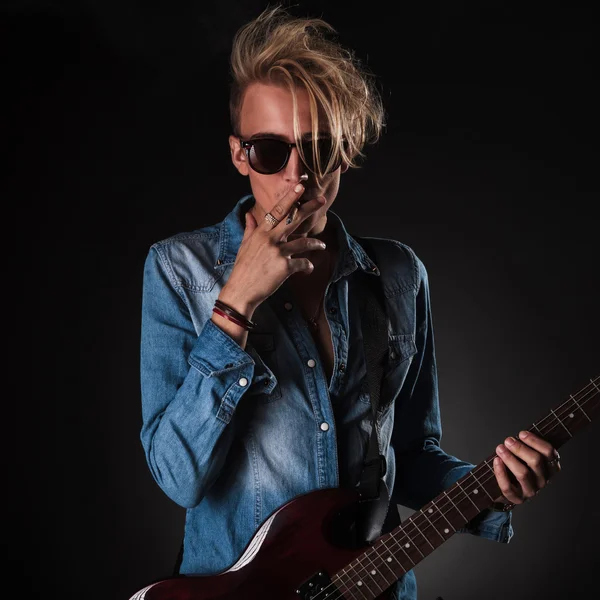 Cool guitarist smoking his cigarette in studio — Stock Photo, Image