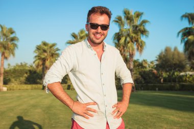 Bel üzerinde gülümseyen genç adam ile ayakta eller