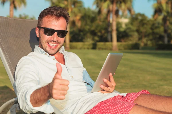 Man att göra ok medan du sitter på en lång stol — Stockfoto