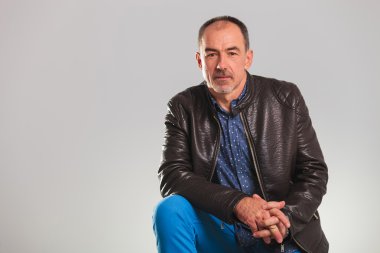 ciddi stüdyoda oturan ihtiyar